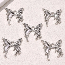 Silver butterfly charms for DIY jewelry making, showing 5 pieces in a row on textured surface