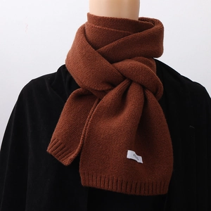 Close-up of thick brown knit scarf featuring a detailed texture and FEU branded label