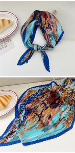 Detailed view of pleated silk scarf with colorful geometric patterns and blue borders