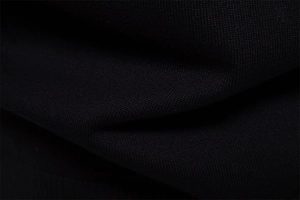 Gros plan sur le tissu en maille noire montrant la texture premium et les détails