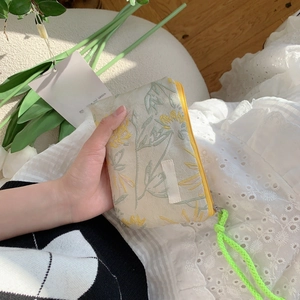 Detailed shot of floral embroidery fabric and vibrant contrast zipper on cosmetics bag