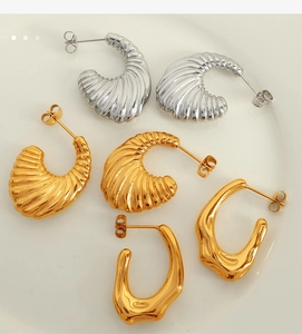 Detailed macro view of gold and silver textured hoop earrings and irregular drop studs