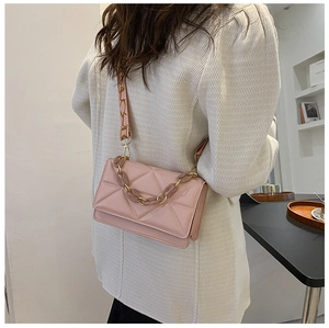Detailed side view of pink quilted crossbody bag with acrylic chain and wide strap