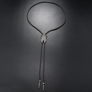 Detail of silver cicada bolo tie pendant with brown braided cord and metal tips