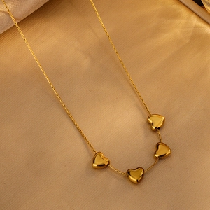 Elegant gold choker necklace with four polished heart-shaped pendants on a fine chain