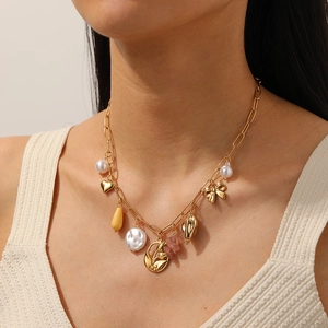 Collier à pendentifs tulipe et nœud dorés avec perles sur mannequin au style chic