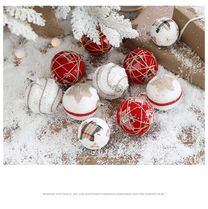 Close-up of red and white glitter foam Christmas balls with rustic twine on snow