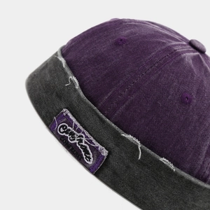 Macro shot of retro brimless hat with embroidery patch and distressed denim edges