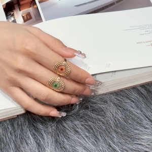 Close-up of adjustable gold rings with dried floral petals inside round glass charms