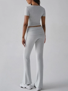 Rear view of a grey casual two-piece crop top and flared trousers sports set for women