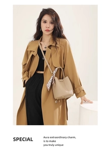 Close-up of beige leather bucket bag with decorative scarf handle and gold metal studs