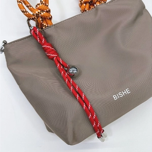 Grey nylon mini handbag with orange climbing rope handle and decorative woven knot