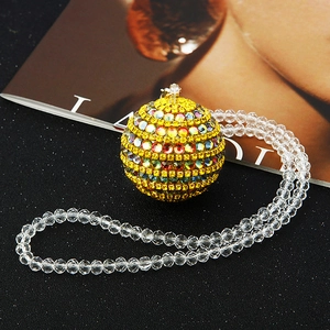 Detailed view of colorful rhinestone-encrusted globe pendant on a beaded car mirror charm