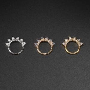 Macro shot of crown-shaped piercing rings with blue and clear zircon gemstones