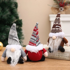 Tre gnomi natalizi in peluche con cappelli di maglia per decorazioni festive