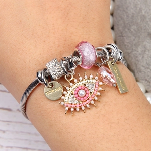 Silver stainless steel cable bracelet with pink beads and evil eye charm on wrist
