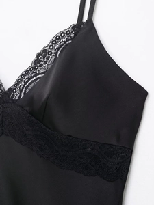Vue détaillée du tissu satiné noir avec dentelle délicate et couture fine du col en V