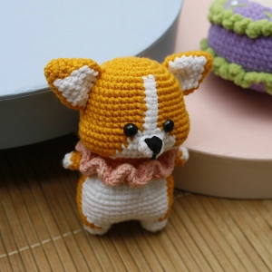Handmade crochet Corgi dog keychain with orange and white yarn and pink collar