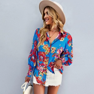 Dettaglio della camicia blu a fiori con maniche a sbuffo e polsini elastici rifiniti