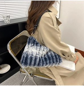 Detail of the blue and white gradient faux fur handbag featuring soft pleated texture and strap