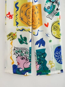 Vue détaillée du pantalon blanc avec imprimés artistiques colorés et motifs de pop art
