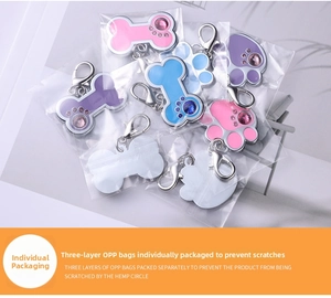 Detail of colorful bone and paw shaped metal pet ID tags with lobster clasps in packaging