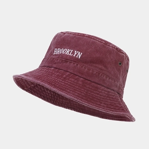 Gros plan sur la broderie Brooklyn et les oillets métalliques d'un bob en coton bordeaux