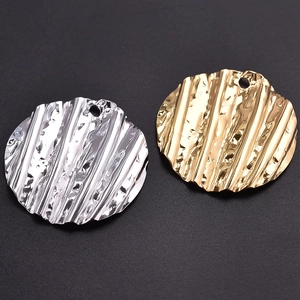 Textured round 304 stainless steel pendants in gold and silver finish on black background