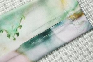 Close-up of colorful tie-dye knit dress featuring high-density stitching and thumbhole detail
