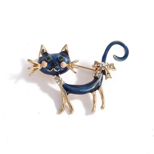 Blue enamel cat brooch with green crystal eyes and gold-plated alloy finish on white background