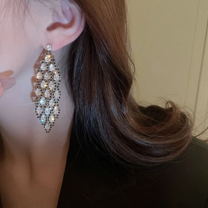 Luxurious silver hollow zircon tassel earrings worn by a model in a profile close-up shot