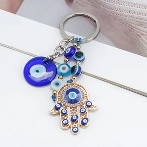 Detailed view of Hamsa Hand keychain with blue evil eye beads and gold metal accents