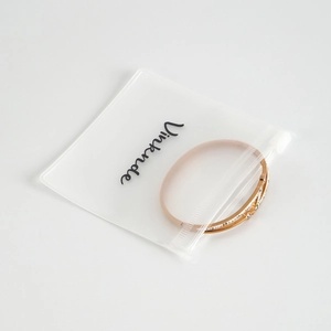 Rose gold screw design bangle with crystals in a matte translucent zip storage bag