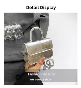 Detail of silver metallic mini bag with crocodile texture and sleek chain strap