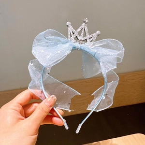 Close-up of light blue mesh headband with crown, bow and star details for girls