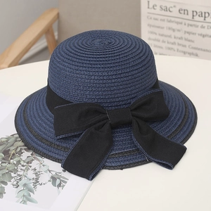 Dettaglio di cappello di paglia blu navy per donna con grande fiocco nero decorativo.