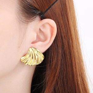 Macro shot of 18K gold plated brushed metal earrings with irregular petal shape