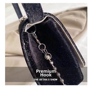 Detail of high-density black velvet evening bag with silver metal hook and bead chain link