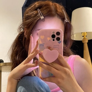 Pink heart iPhone case with 3D pop socket and orange prints shown in mirror selfie