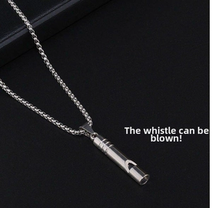 Close-up of functional silver whistle pendant necklace with textured ring grooves