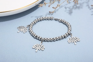 Vue détaillée du bracelet à perles argentées avec trois pendentifs arbre de vie