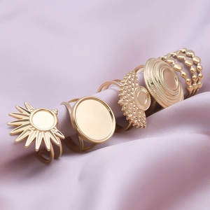 Minimalist gold stainless steel geometric ring set on purple silk background