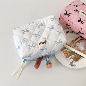 Detailed interior view of quilted cotton cosmetic bags with blue ribbon patterns