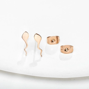 Minimalist rose gold tadpole stud earrings with wavy design on a white ceramic base
