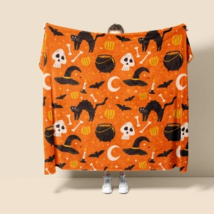 Macro shot of Halloween flannel blanket featuring orange print with black cats and pumpkins