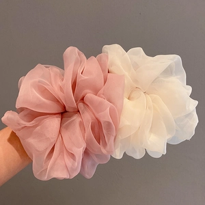 Macro view of soft pink and beige chiffon scrunchies with elegant ruffled texture