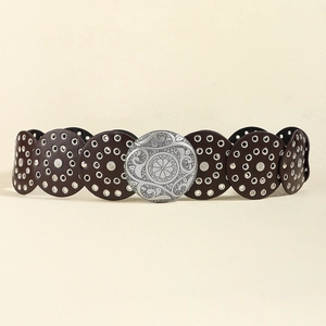 Dettaglio di cintura western vintage con fibbia floreale intagliata e maglie in pelle tonde
