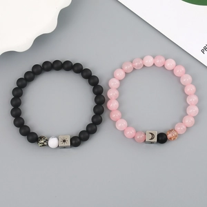 Detail of sun and moon couple bracelets featuring matte black and pink stone beads