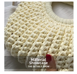 Detailed macro view of cream-colored hand-knitted bag showing thick textured crochet weave