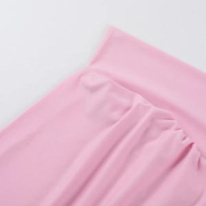 Gros plan du haut en maille rose à épaules dénudées montrant la texture du tissu